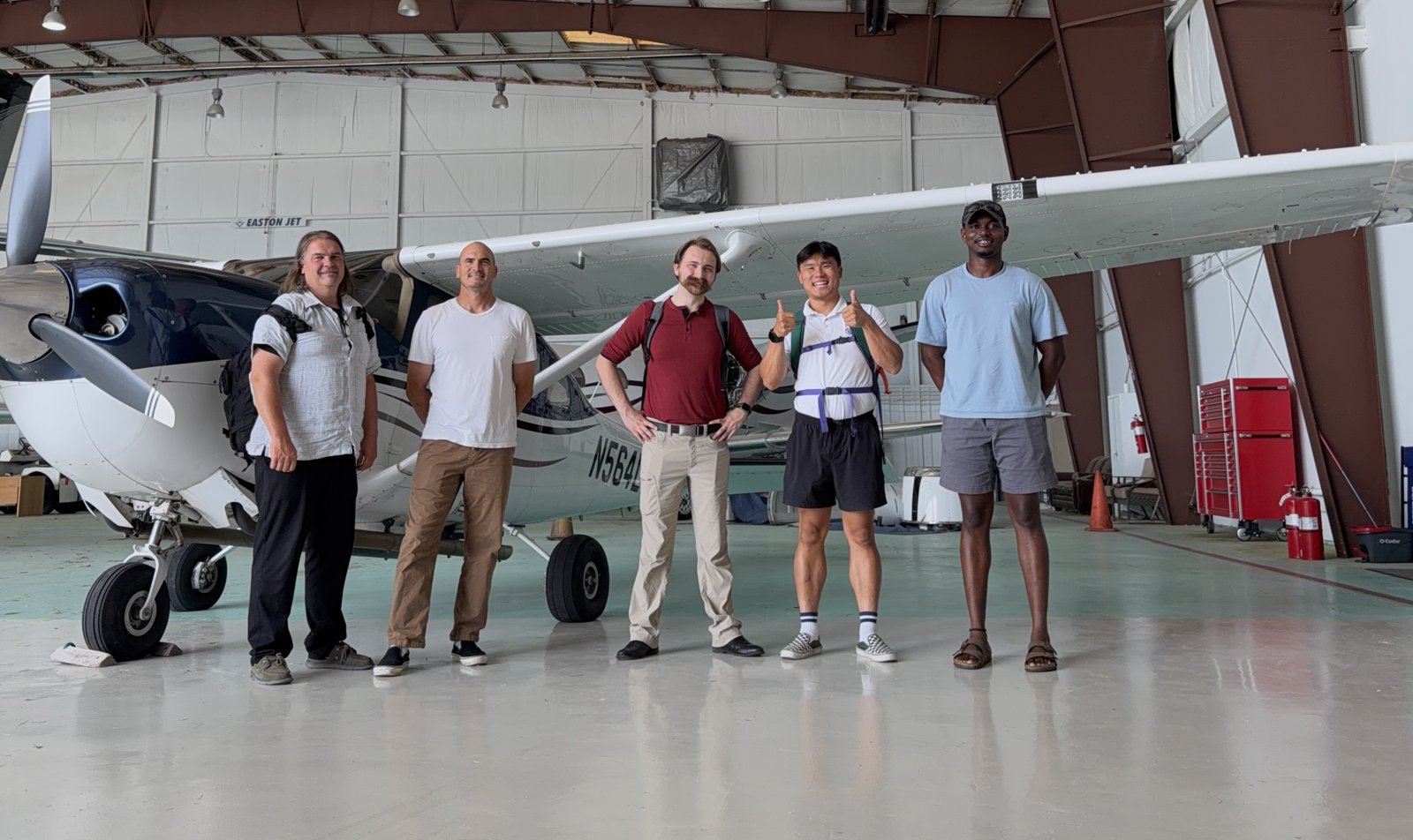 The Horizonview team beside the Cessna C206H Stationair in the hangar